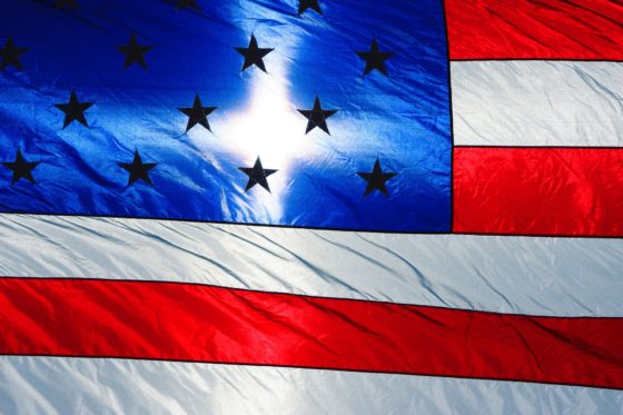 American flag, backlighted so that a white cross appears on the blue canton with white stars