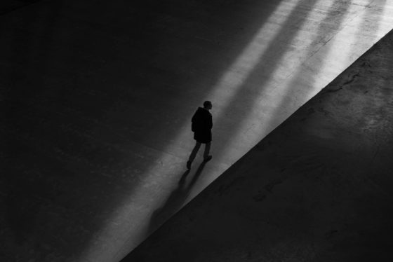Sihouette of man walking toward light