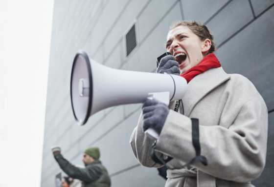 A woman yells through a megaphone