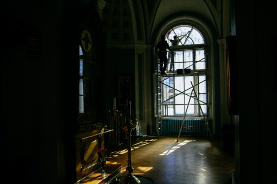 A man works to repair a church window.