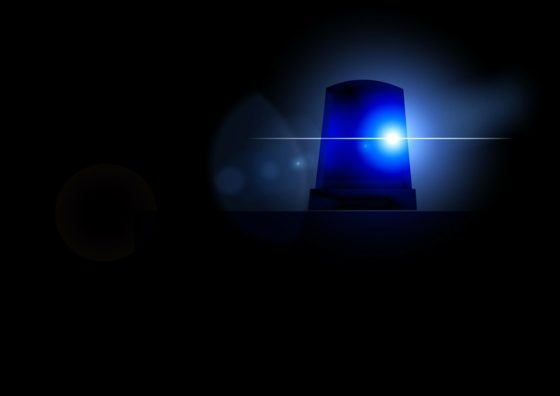 A blue police light shining in a dark background.